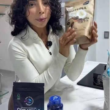Mujer mostrando la proteína y la creatina de Sin Intermediarios en su cocina